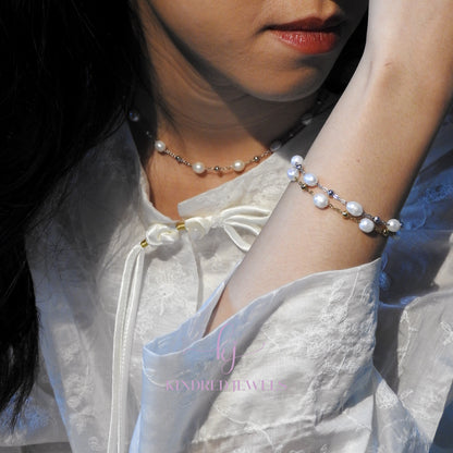 Person wearing a pearl bracelet and necklace with a blurred background