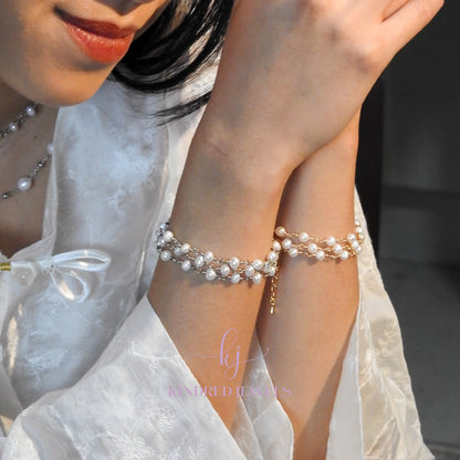 Close-up of a person wearing pearl bracelets with a blurred background